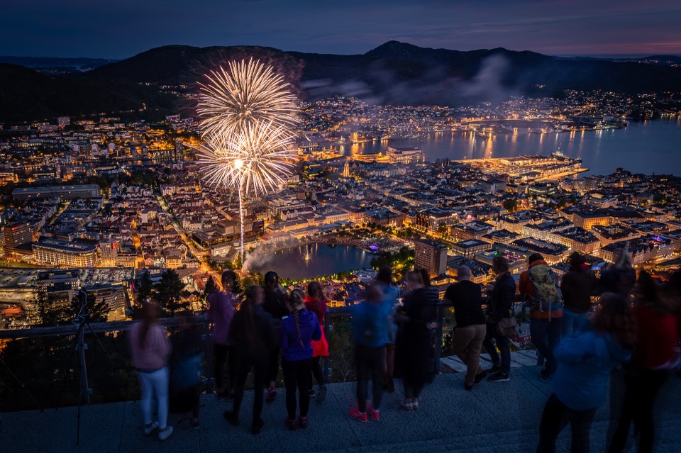 Fireworks exploding over the city of Bergen at night, seen from above